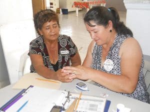 promotora measures blood sugar